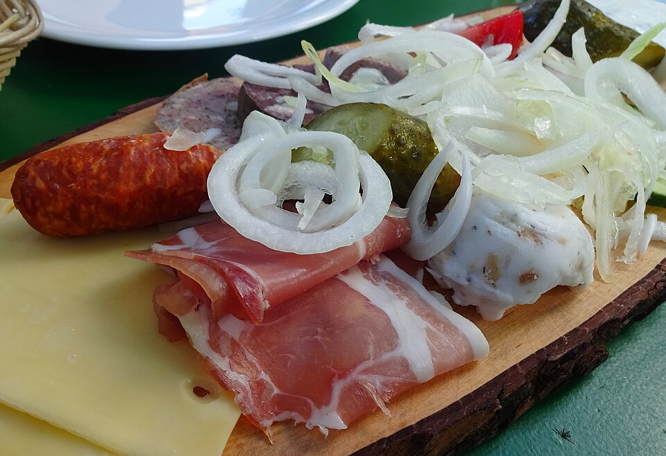 Brotzeitplatte mit aufgeschnittenem geräuchertem Schinken und Rohwurst