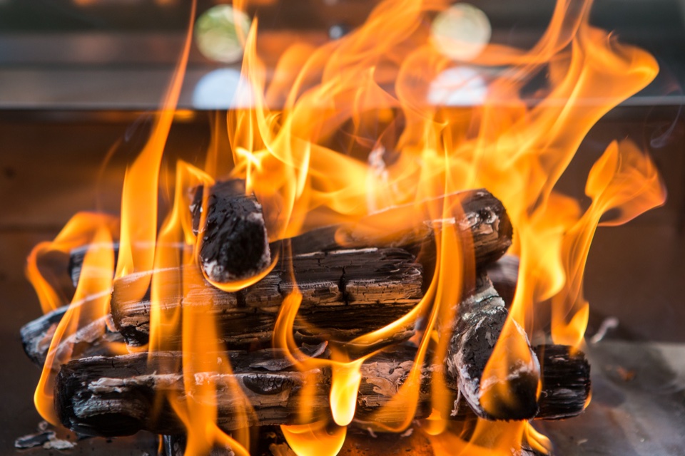 Brennendes Holz im Edelstahl-Heizschub eines Beelonia-Räucherofens