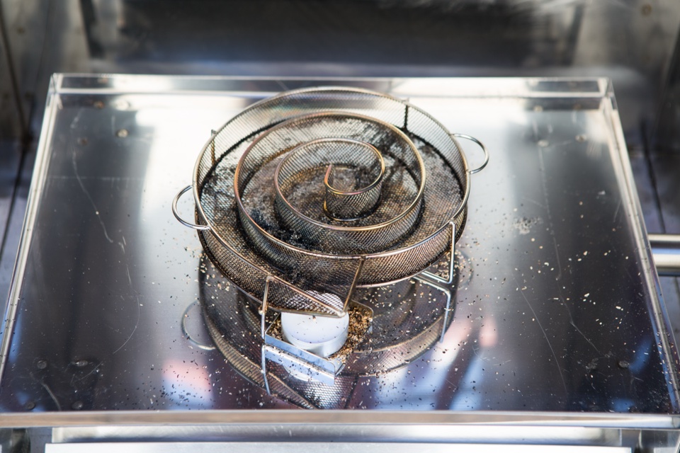 Sparbrand-Spirale mit Räuchermehl auf dem Einschub eines Beelonia-Räucherofens